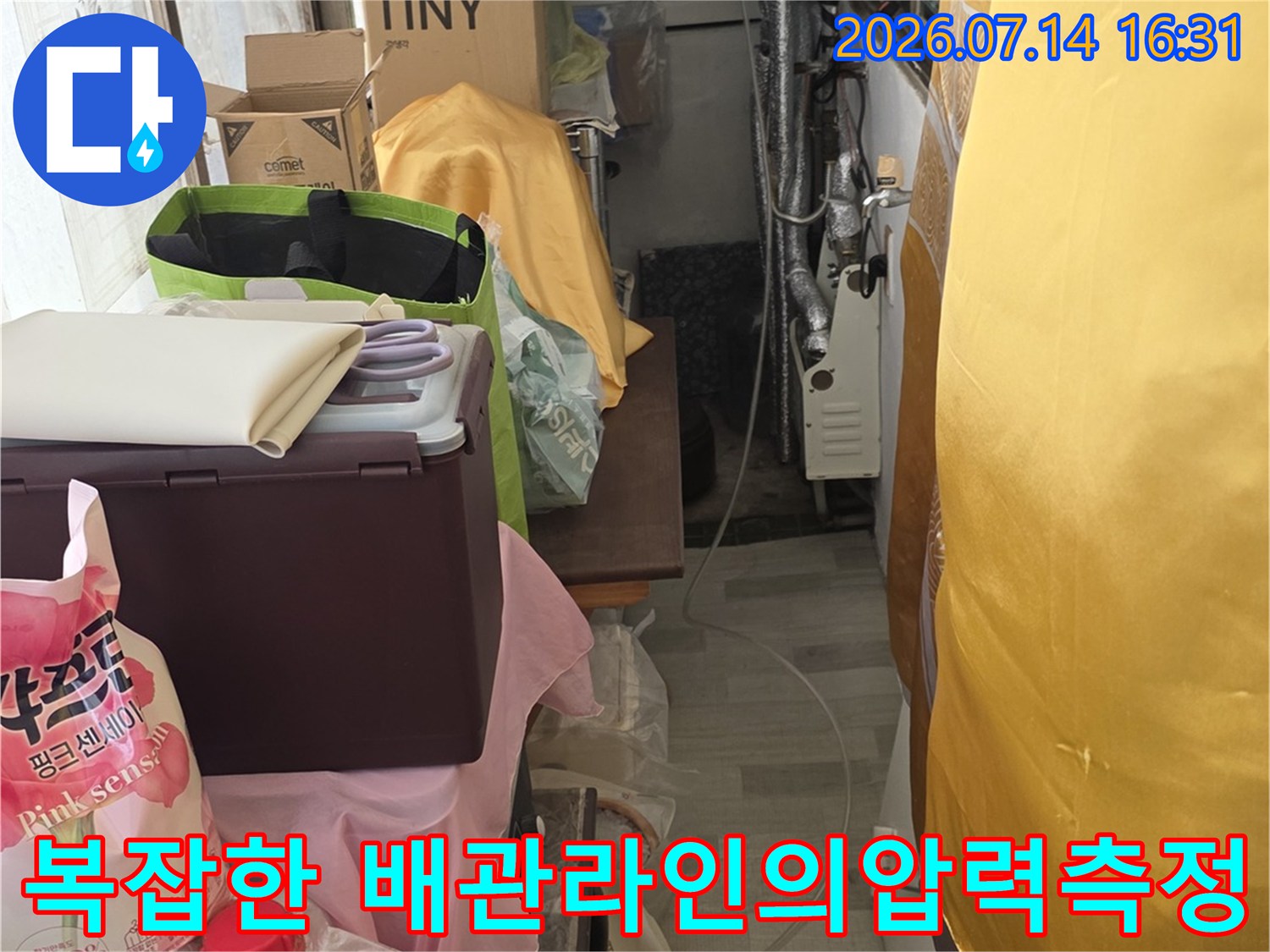 싱크대 하단부에 위치한 여러 가닥의 배관을 정밀 장비로 점검하고 있는 모습