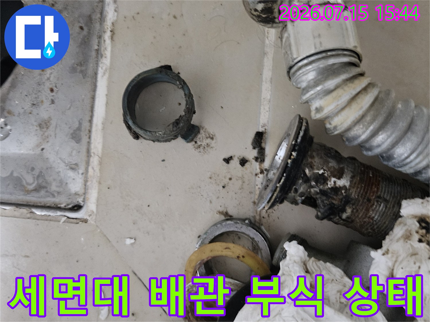 부식된 세면대 하부 연결 배관과 주변 오염물질 상태