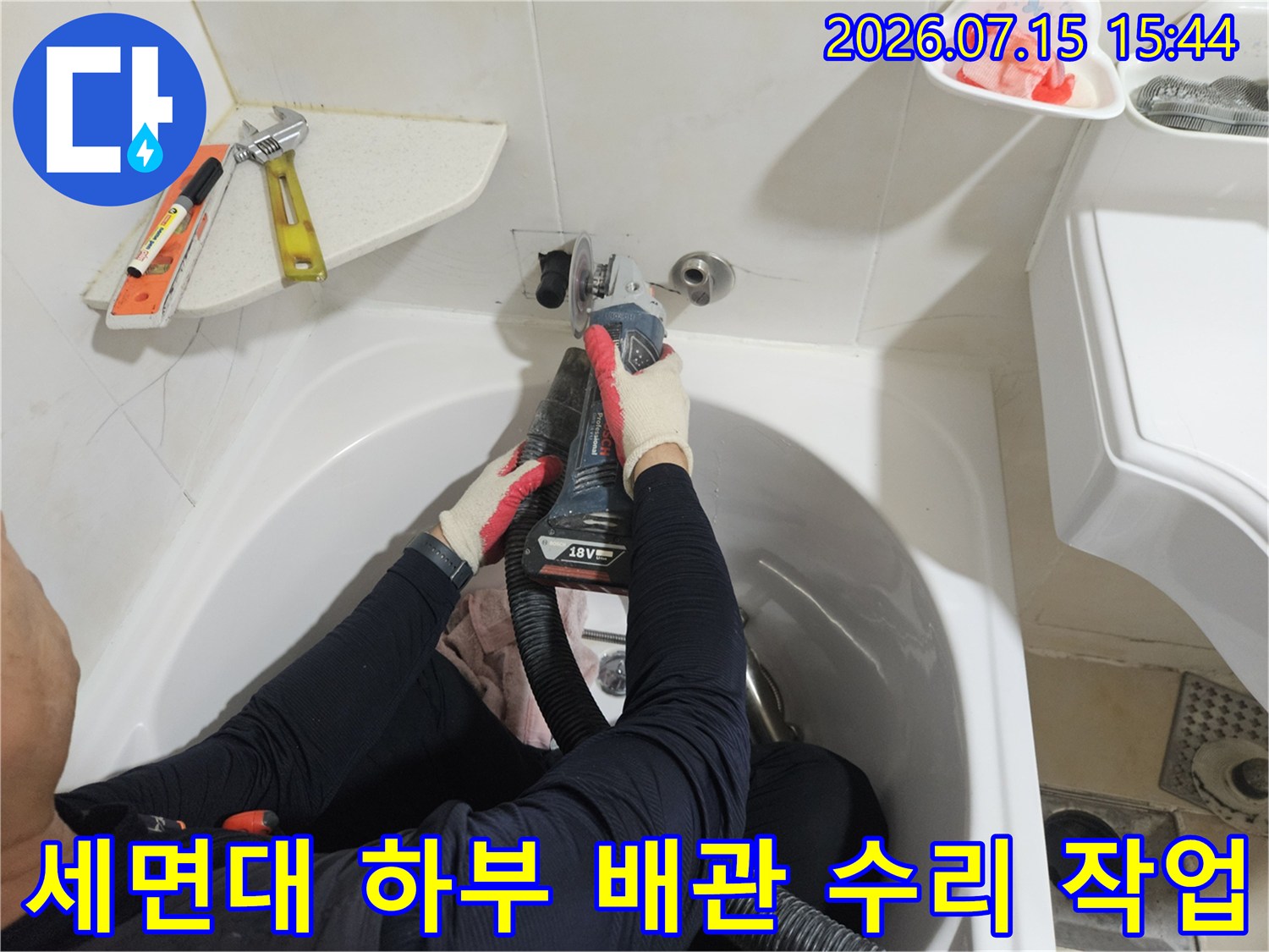 세면대 아래 노출된 온수 배관을 전문 장비로 점검하는 모습
