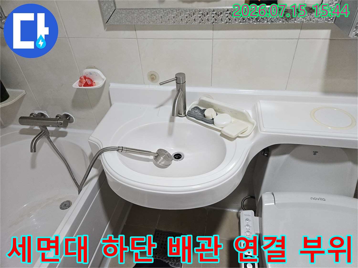 세면대 아래쪽 노출된 수전과 배수 트랩의 구조적 점검 모습