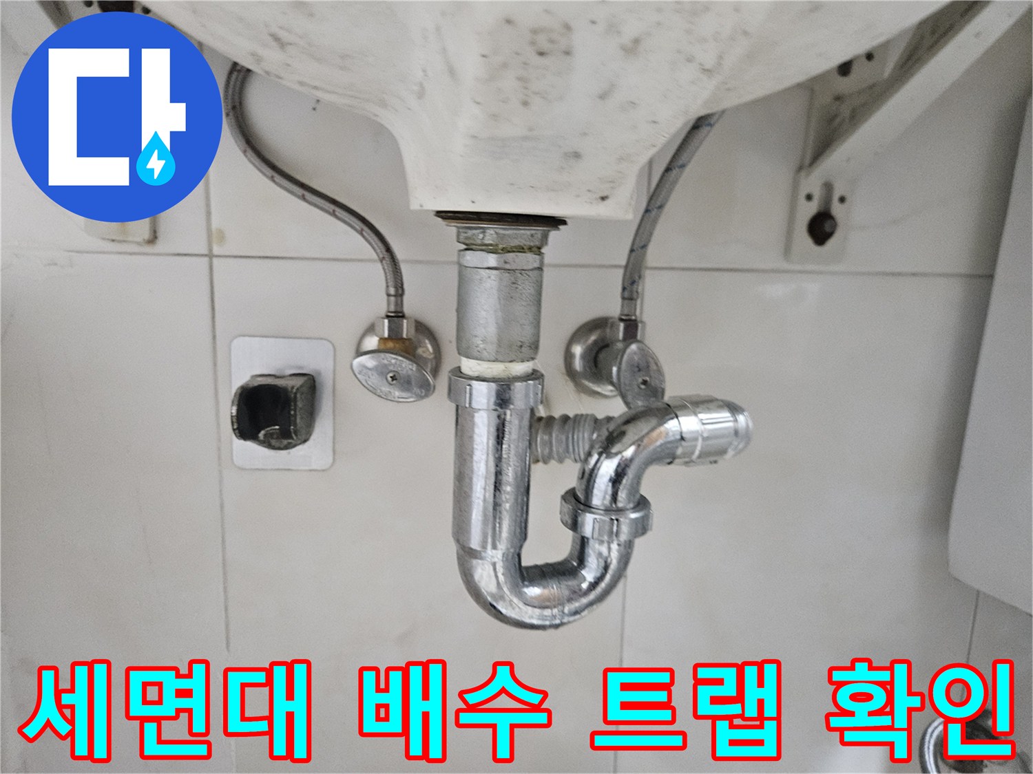 세면대 하단에 설치된 배수 트랩과 급수 밸브