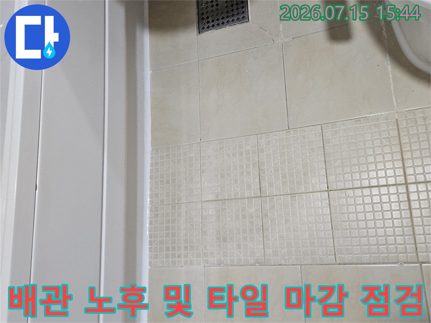 세면대 하부 공간의 노출된 배관과 주변 타일 상태를 촬영한 사진