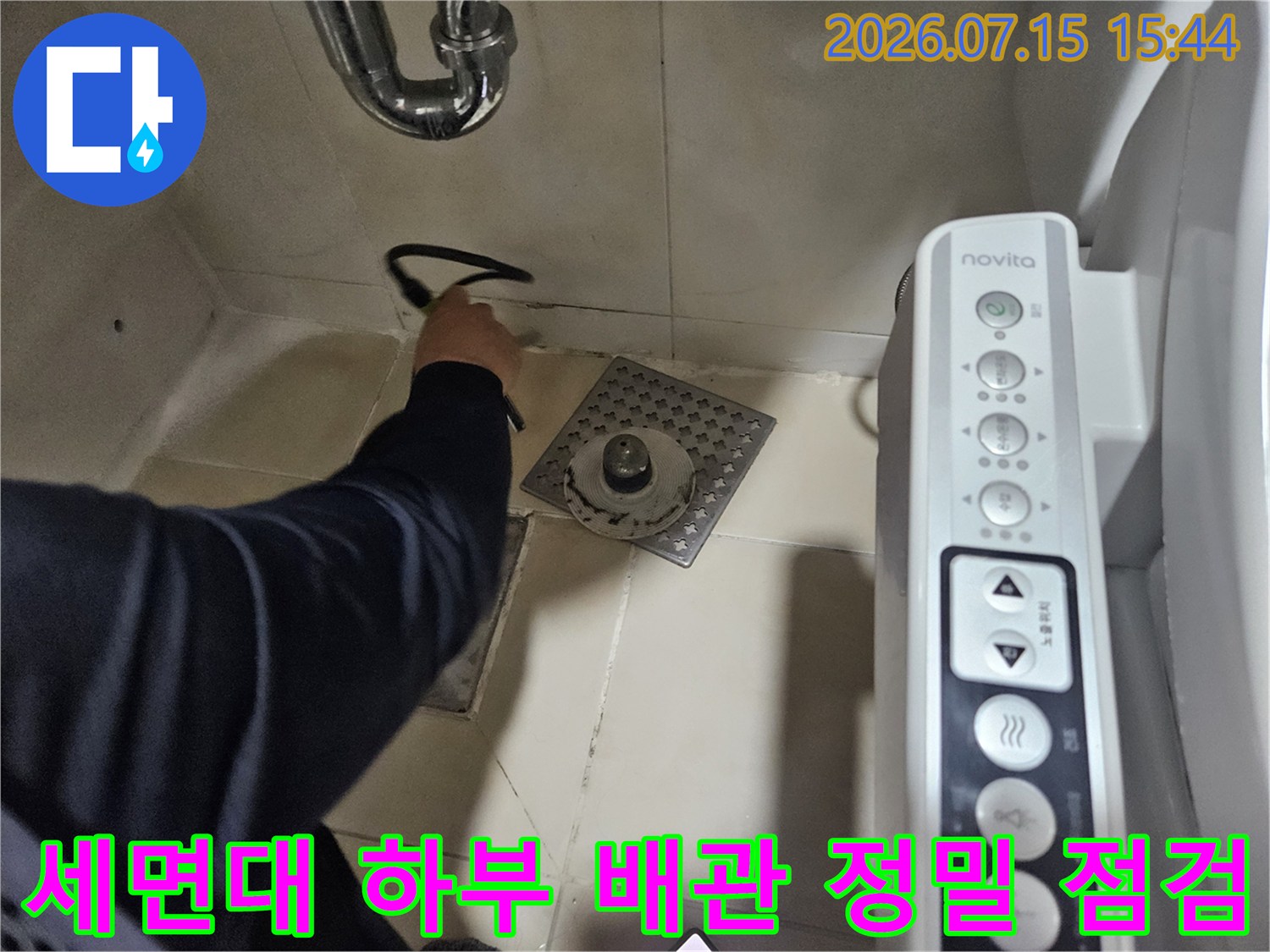 전문가가 세면대 아래 설치된 수도 배관의 노후 및 누수 발생 지점을 탐지기로 확인하는 장면