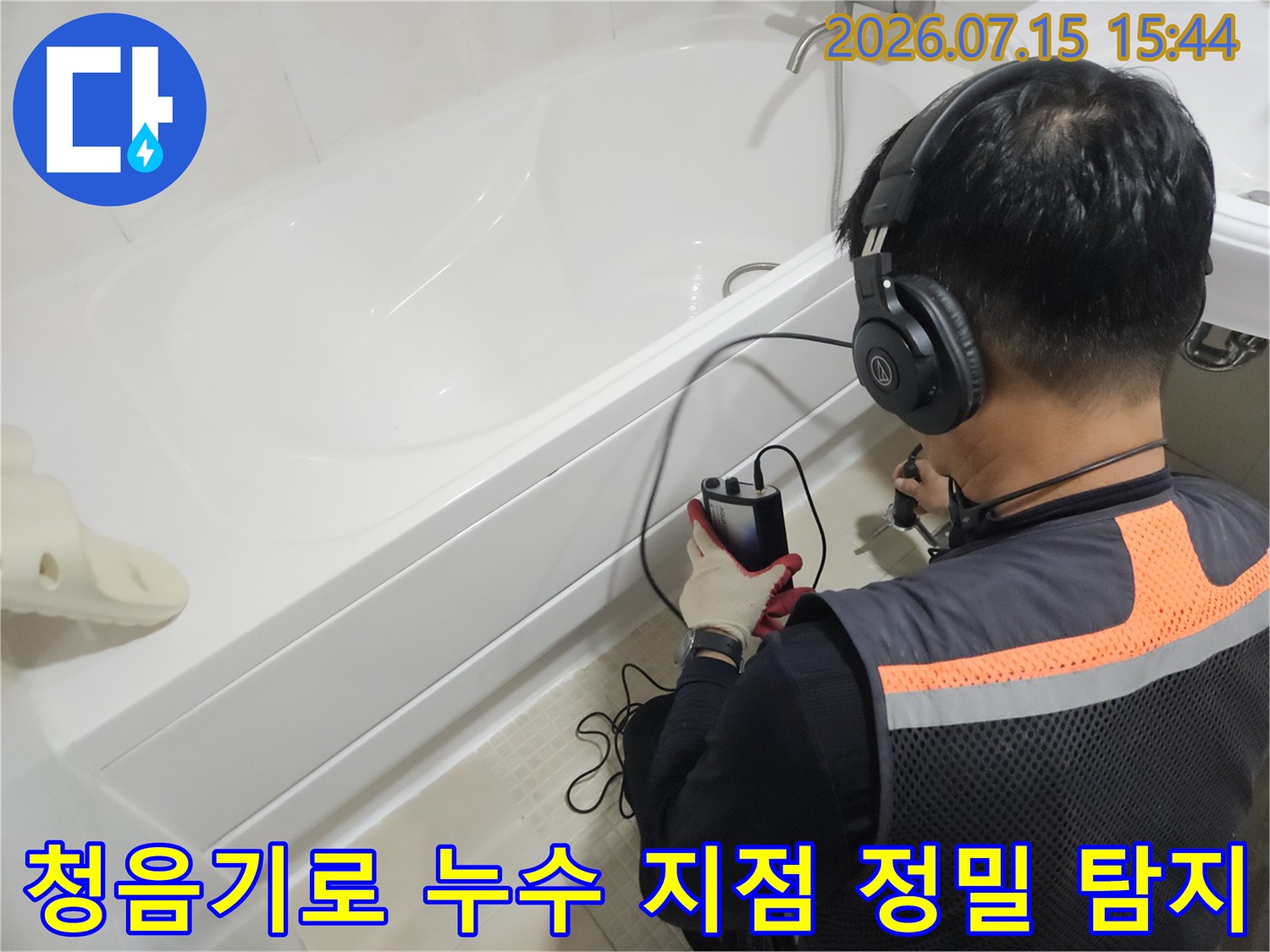 전문가가 청음 장비를 사용하여 욕실 내 배관 누수 위치를 찾는 모습