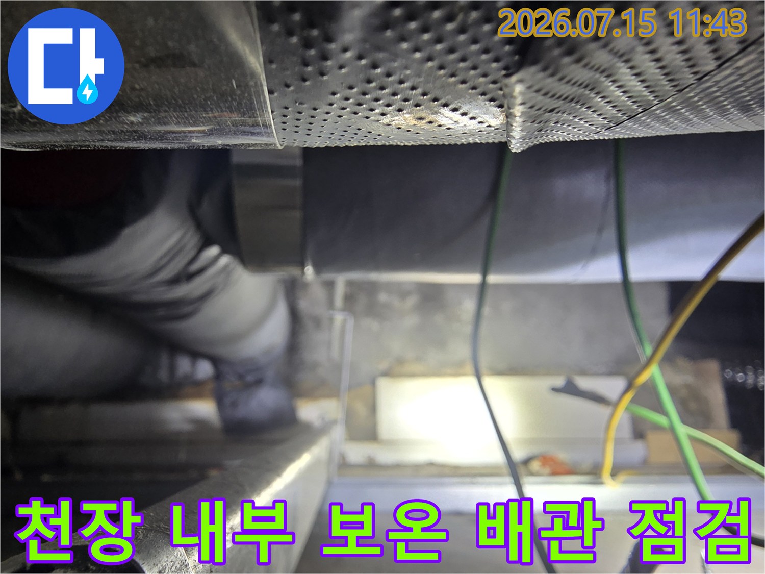 보온재로-감싸인-배관과-노란색-전선이-보이는-천장-내부-작업-현장