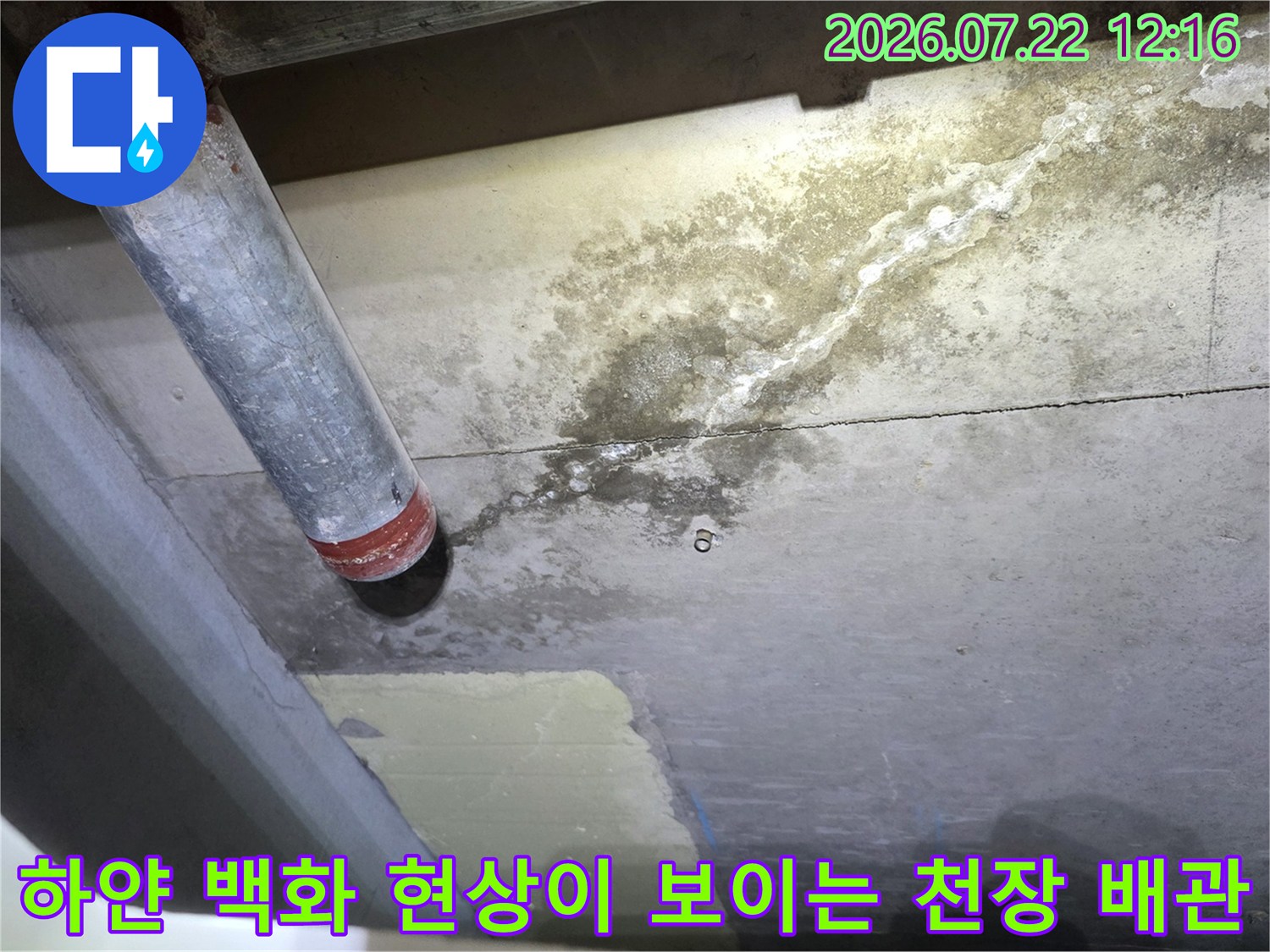금속 파이프 연결부와 콘크리트 천장의 하얀색 누수 오염 흔적-사진