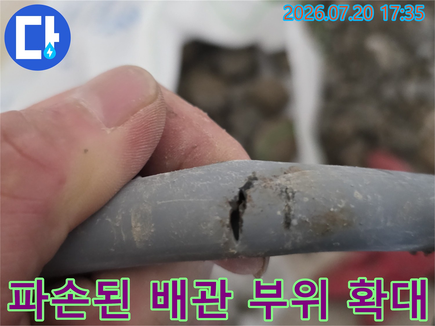 갈라진 회색 배관의 파손 구간을 집중적으로 보여주는 사진