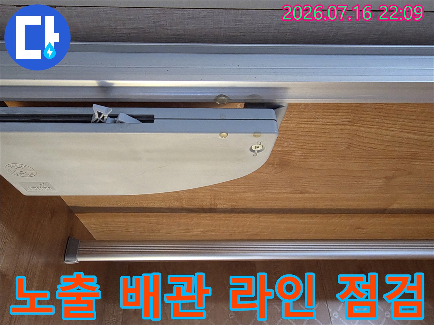 베란다 내부에 노출된 에어컨 배관과 금속 프레임 구조물의 연결 부위를 세밀하게 촬영한 사진