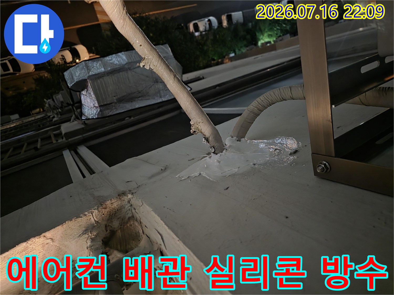 에어컨 배관 연결 부위의 노후된 마감재를 제거하고 실리콘으로 보강하는 모습