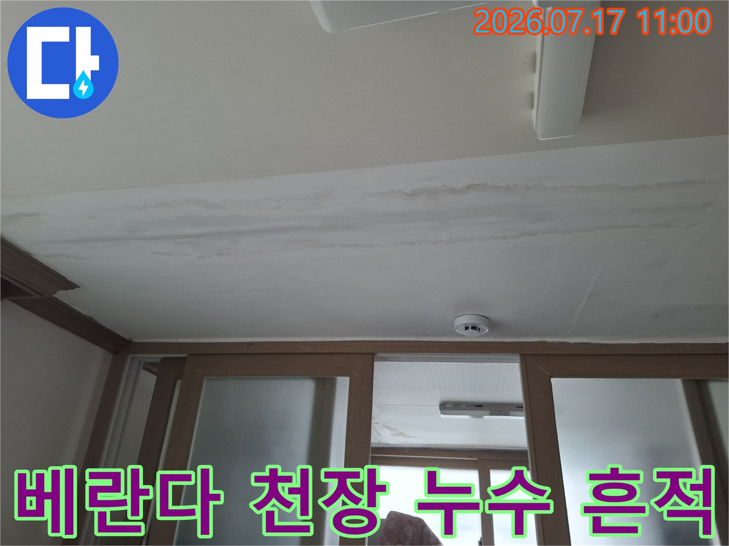 천장 마감면에 물이 번져서 생긴 얼룩과 변색을 근접 촬영한 사진
