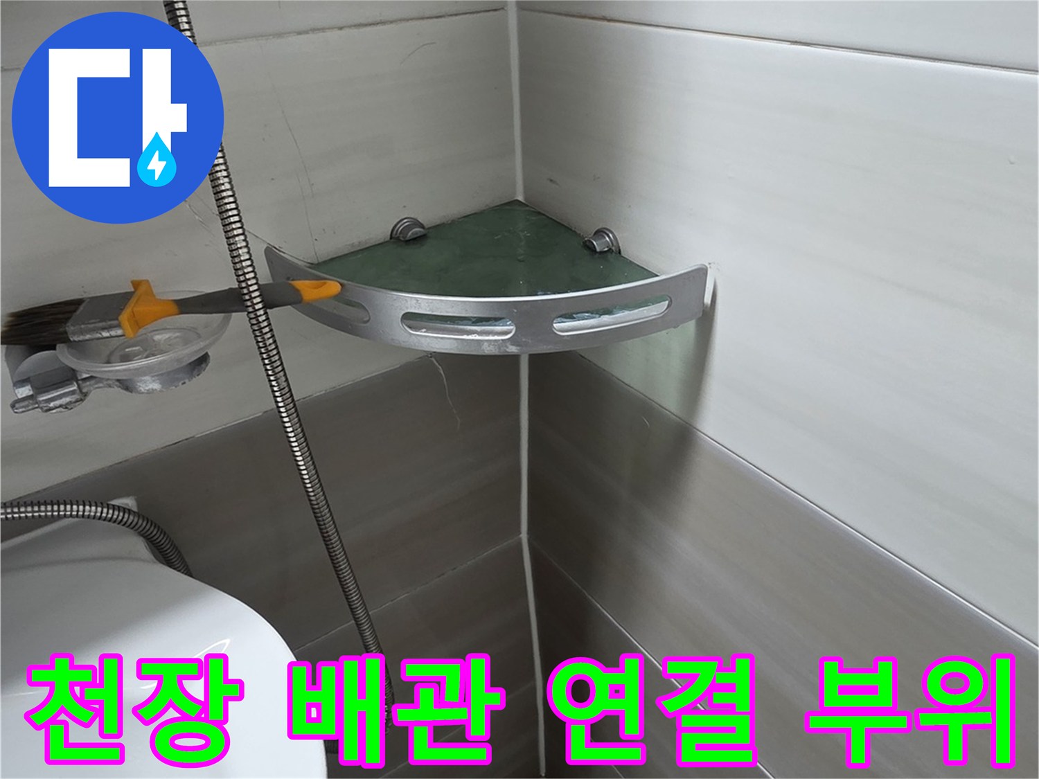 배관의 연결 지점과 주변 타일 사이의 틈새를 점검 중입니다.
