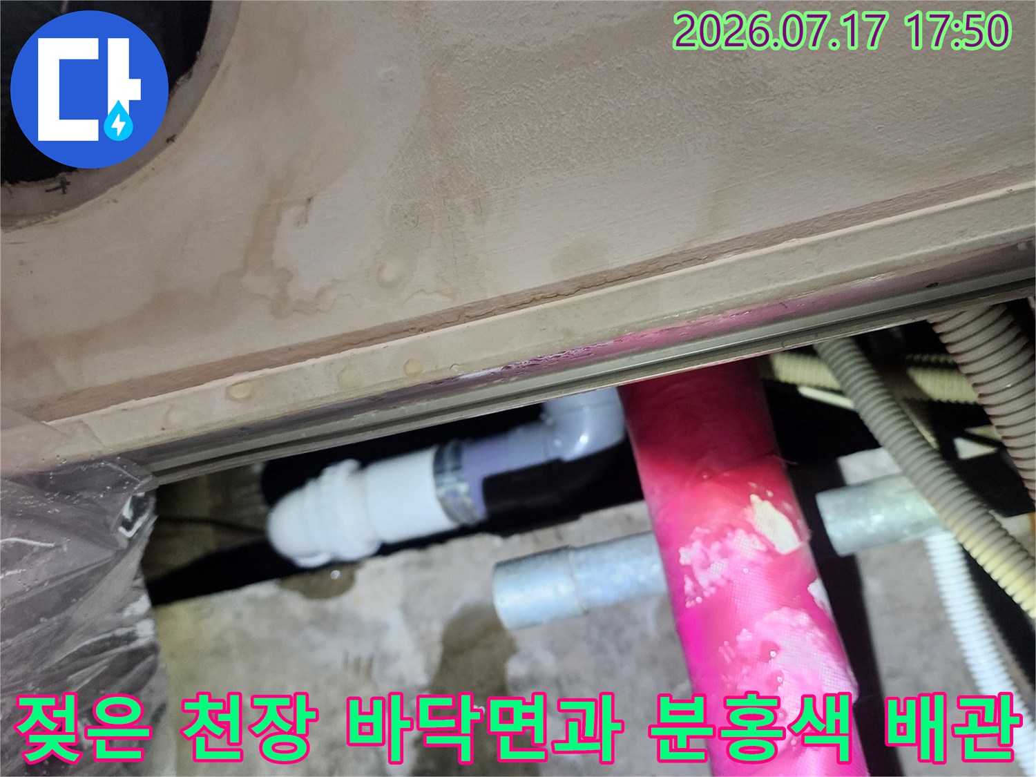 물-얼룩이-심한-콘크리트-천장-표면과-분홍색-보온재가-씌워진-배관들