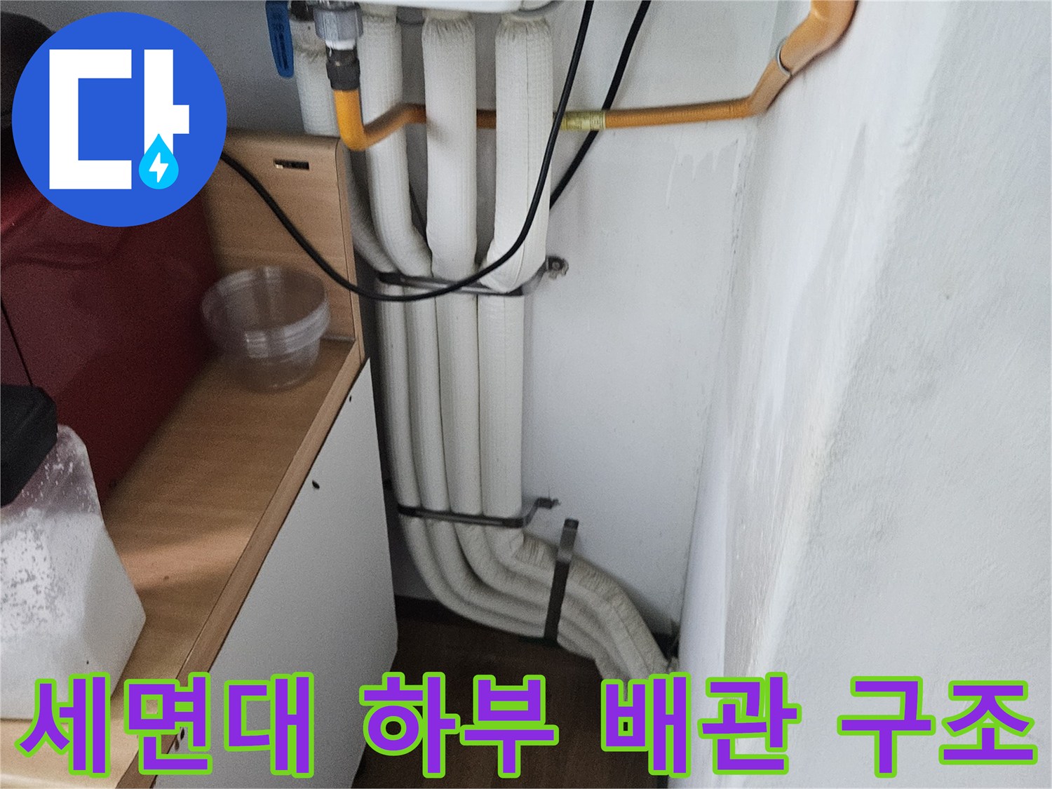세면대 아래쪽의 여러 가닥 배관이 나열된 모습-배관 점검 중