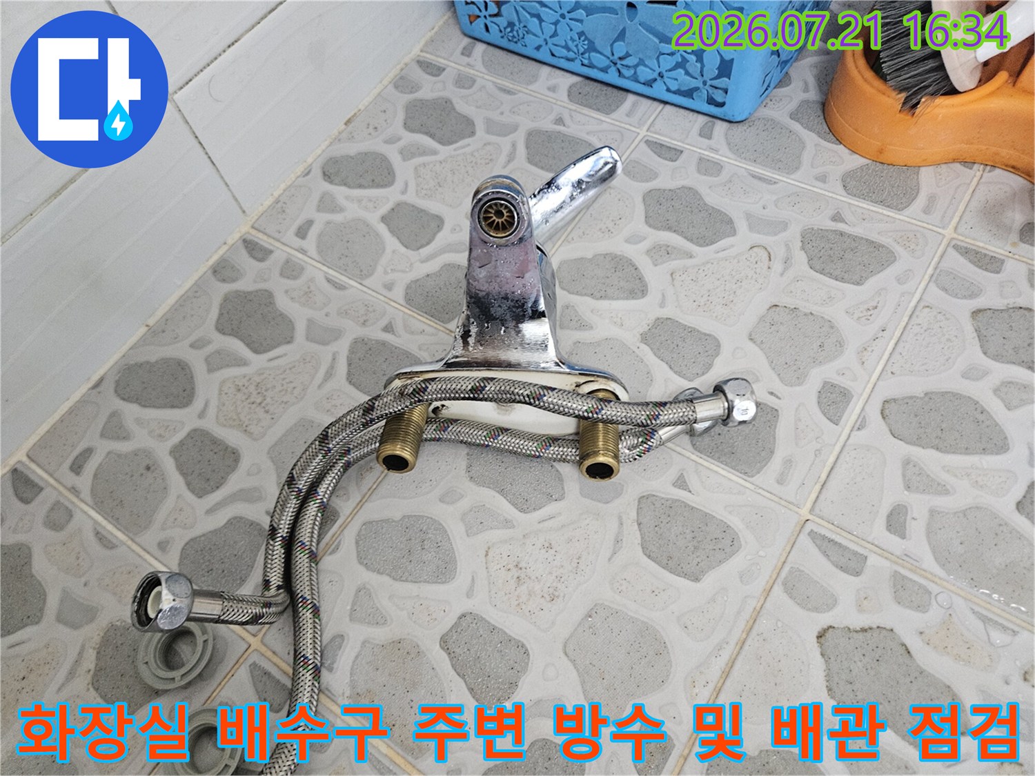 화장실 바닥 타일을 걷어내고 노출된 배수구 주변의 스테인리스 배관과 연결 부위를 정밀 점검하는 모습