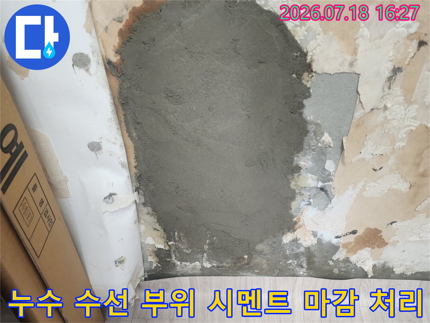 벽지 일부가 제거된 벽면에 배관 수리를 마치고 시멘트로 면을 잡은 모습