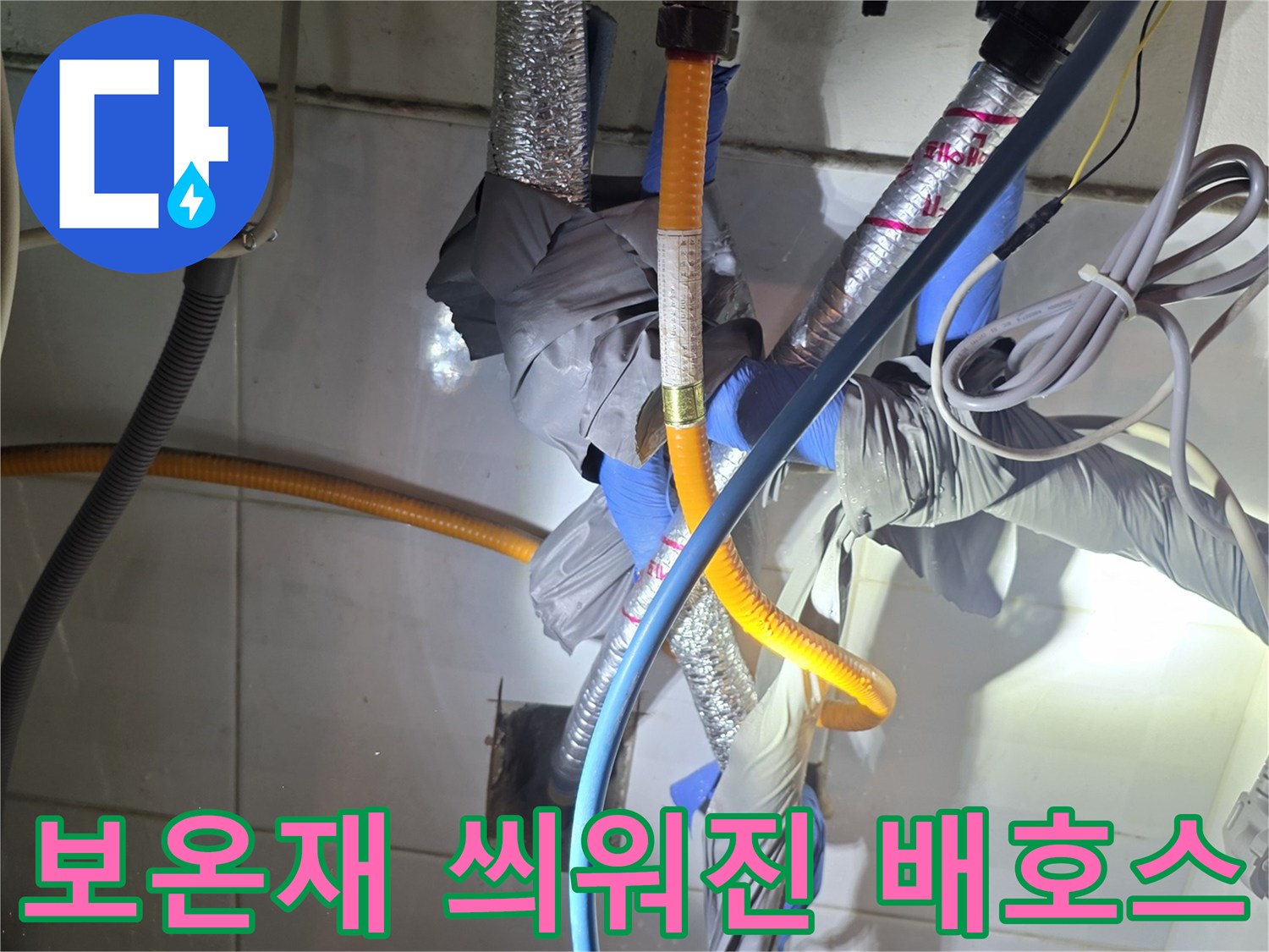 은박 보온재와 파란색 호스가 교차하는 배관 구조물입니다.