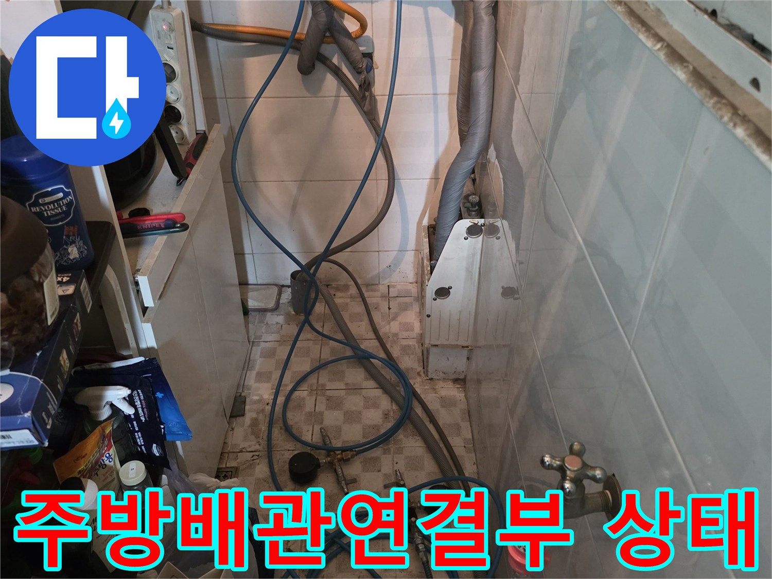 주방 싱크대 하단 배관과 수도 밸브가 복잡하게 연결된 모습