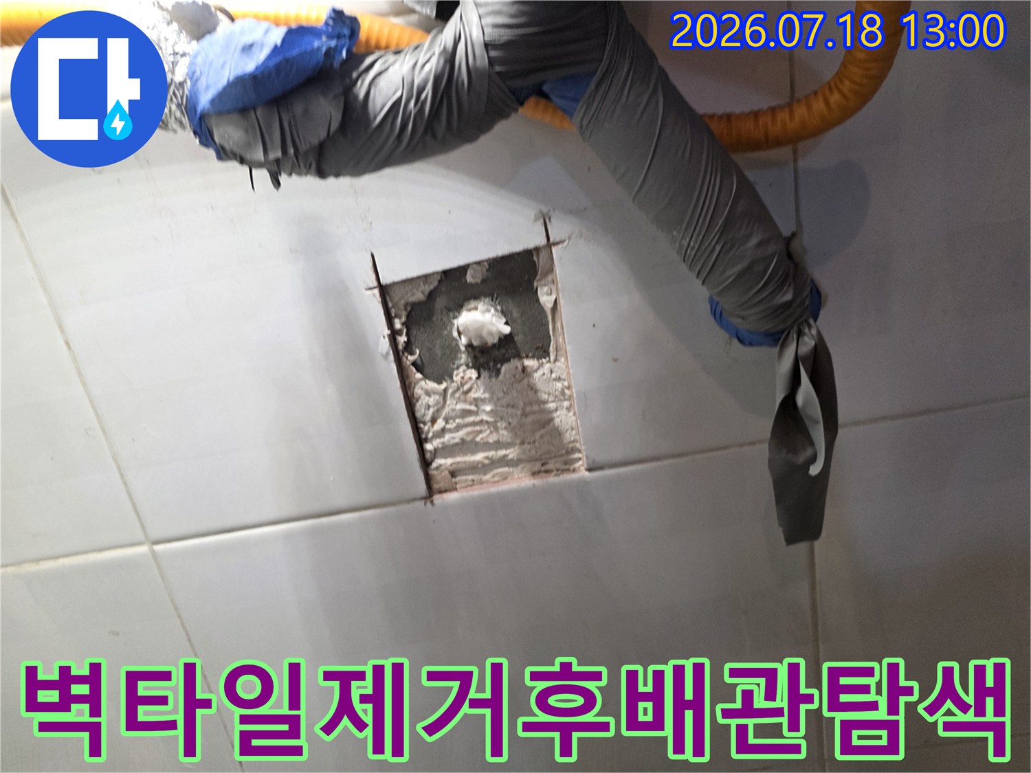 흰색 타일 벽면의 일부가 사각형으로 파내어져 내부 구조가 드러난 사진