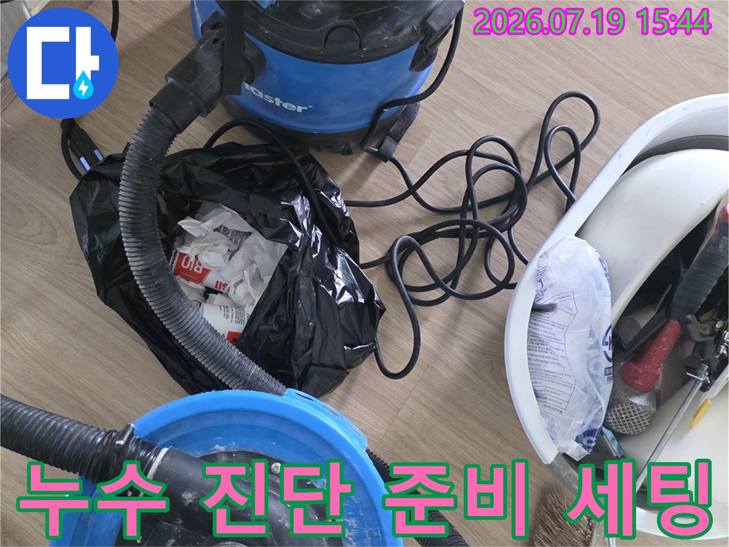 바닥에 배치된 파란색 습식 청소기와 공구함-쓰레기봉투