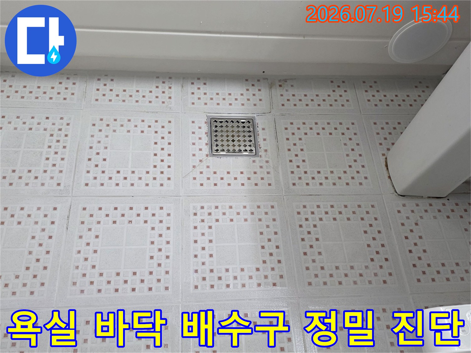 흰색-패턴-타일-중앙의-스테인리스-배수구-덮개