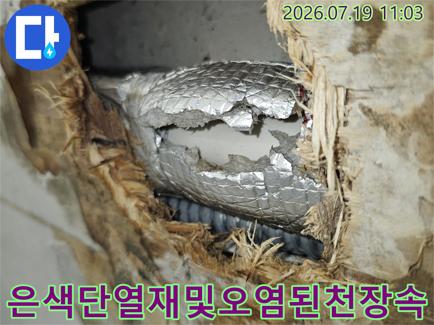누수로 인해 갈색으로 변한 천장 내부 구조물과 은색 배관 보온재의 모습