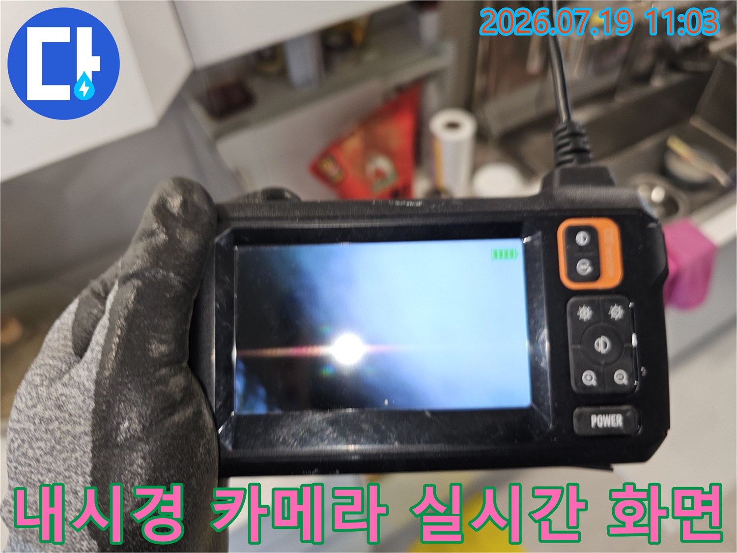 작업자가 손에 쥐고 있는-내시경 모니터 속 천장 내부 배관 영상
