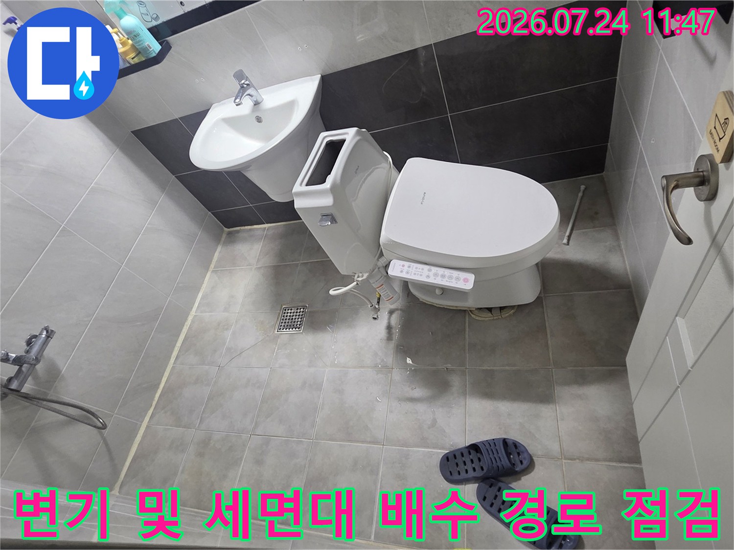 욕실 내 변기와 세면대 주변의 배관 연결 상태를 촬영한 사진