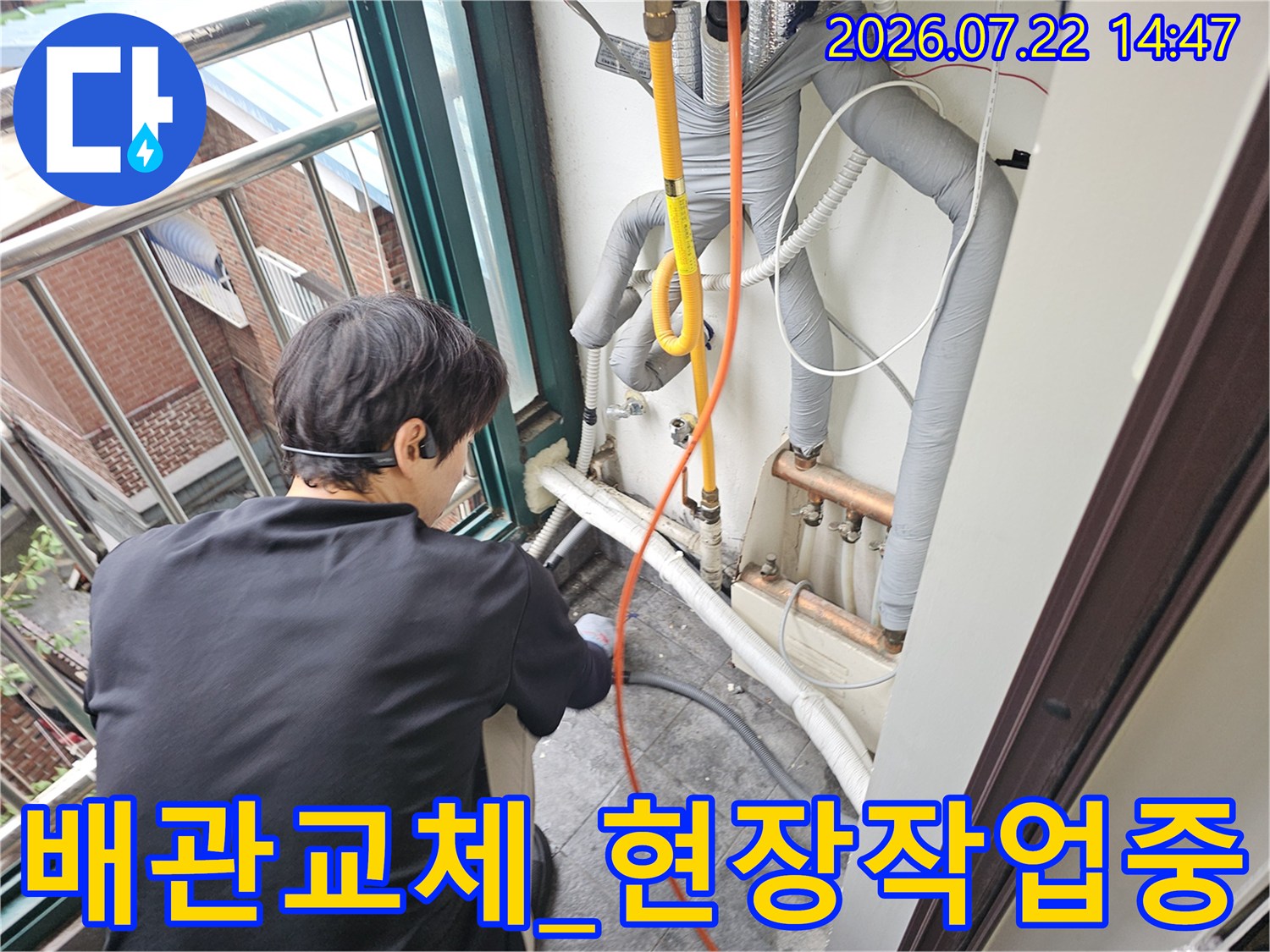 보일러실 내 노란색 배관의 파손 부위를 보수하고 있는 엔지니어의 작업 현장