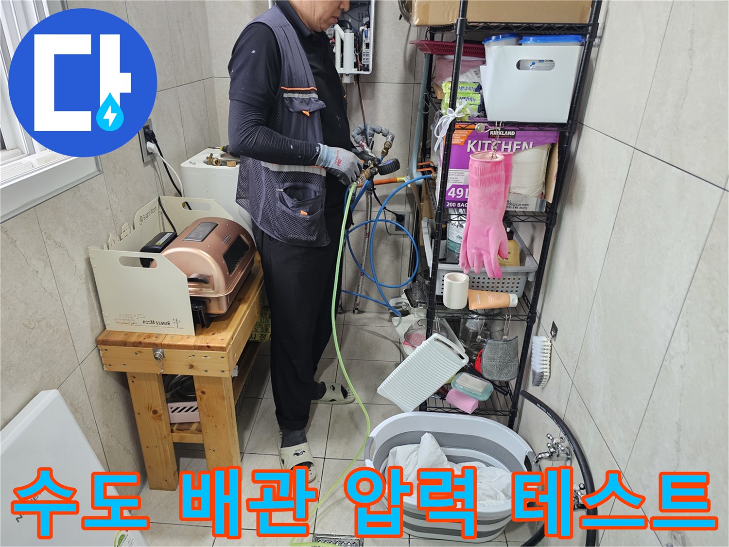 화장실 벽면 근처-배관 연결 부위의 누수를 찾기 위한 장비 설치 장면
