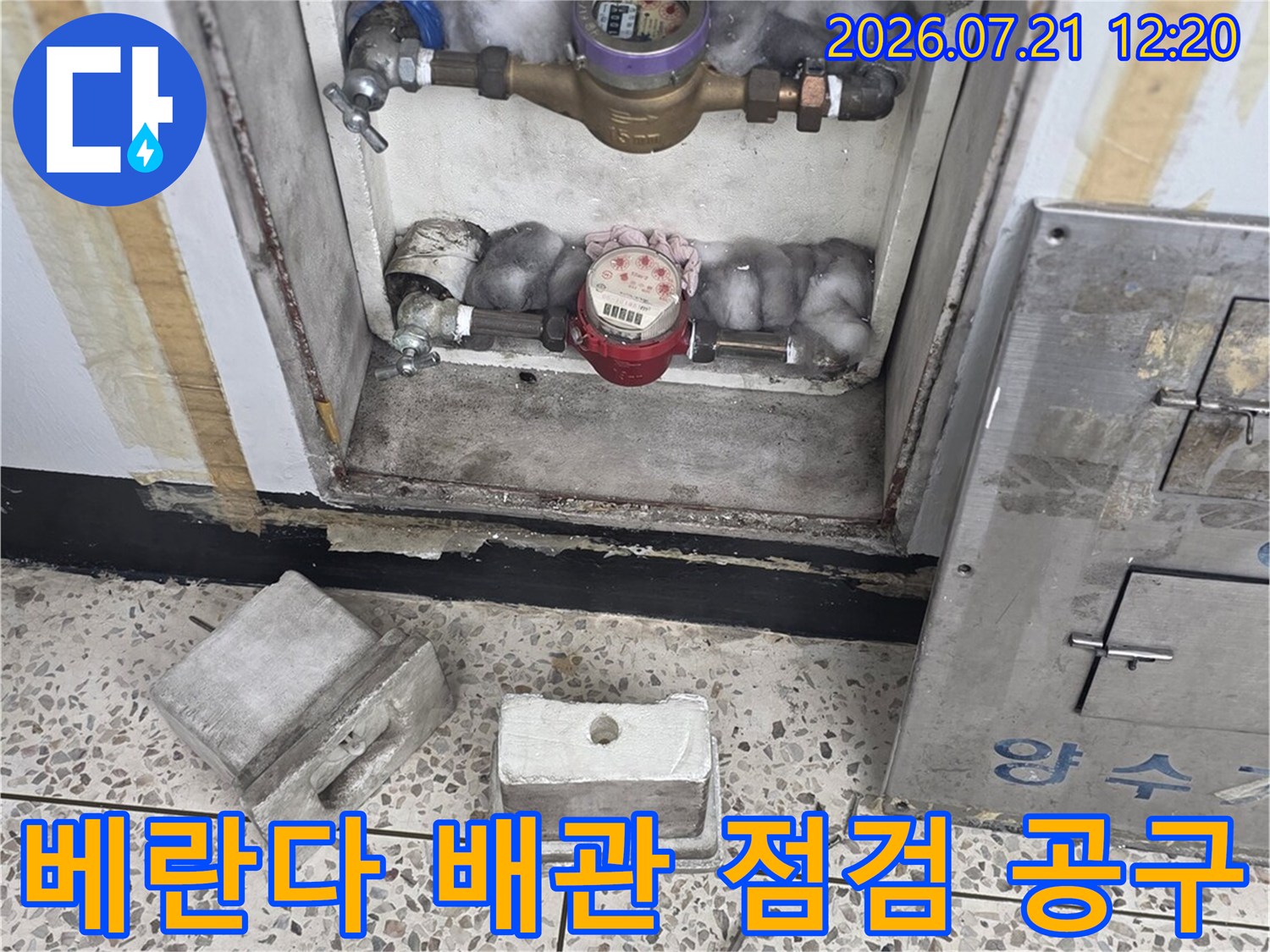 점검 장비와 배관 계량기가 위치한 베란다 구석