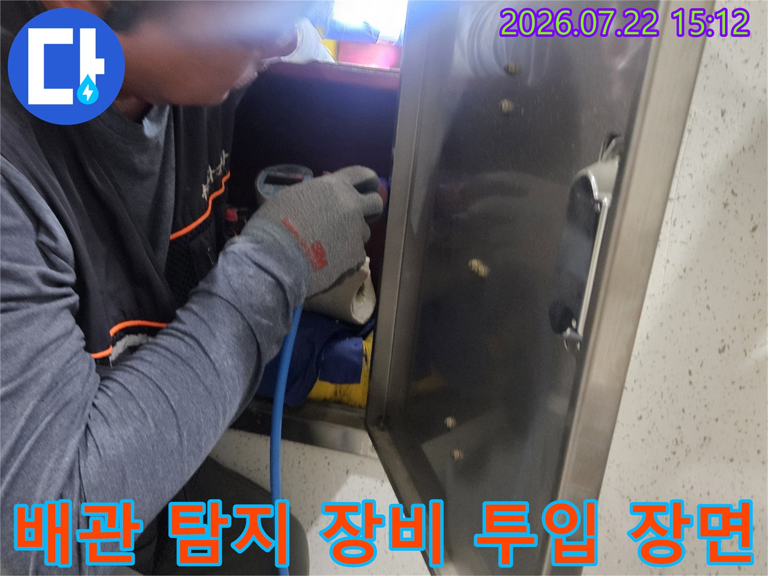 파란색 연결 호스가 달린 전문 탐지 장비를 천장 내부로 넣어 점검하는 작업자의 모습
