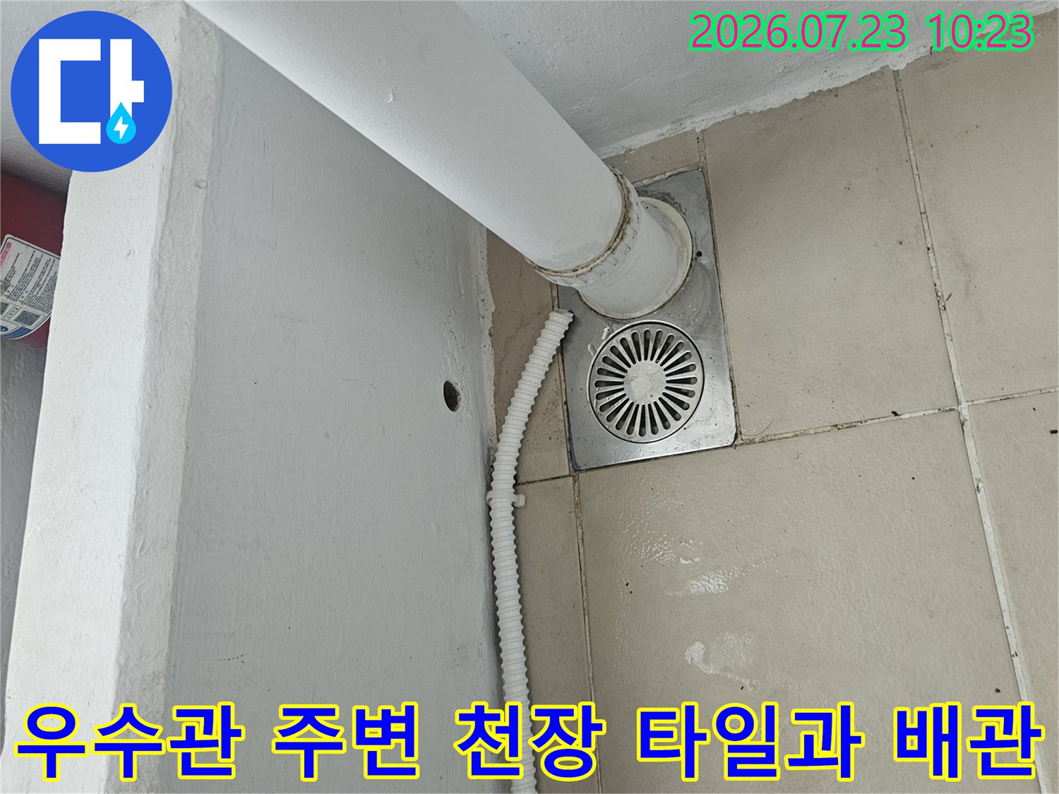 베란다 천장 타일에 고정된 우수관과 은색 환기구 모양의 마감 캡 사진