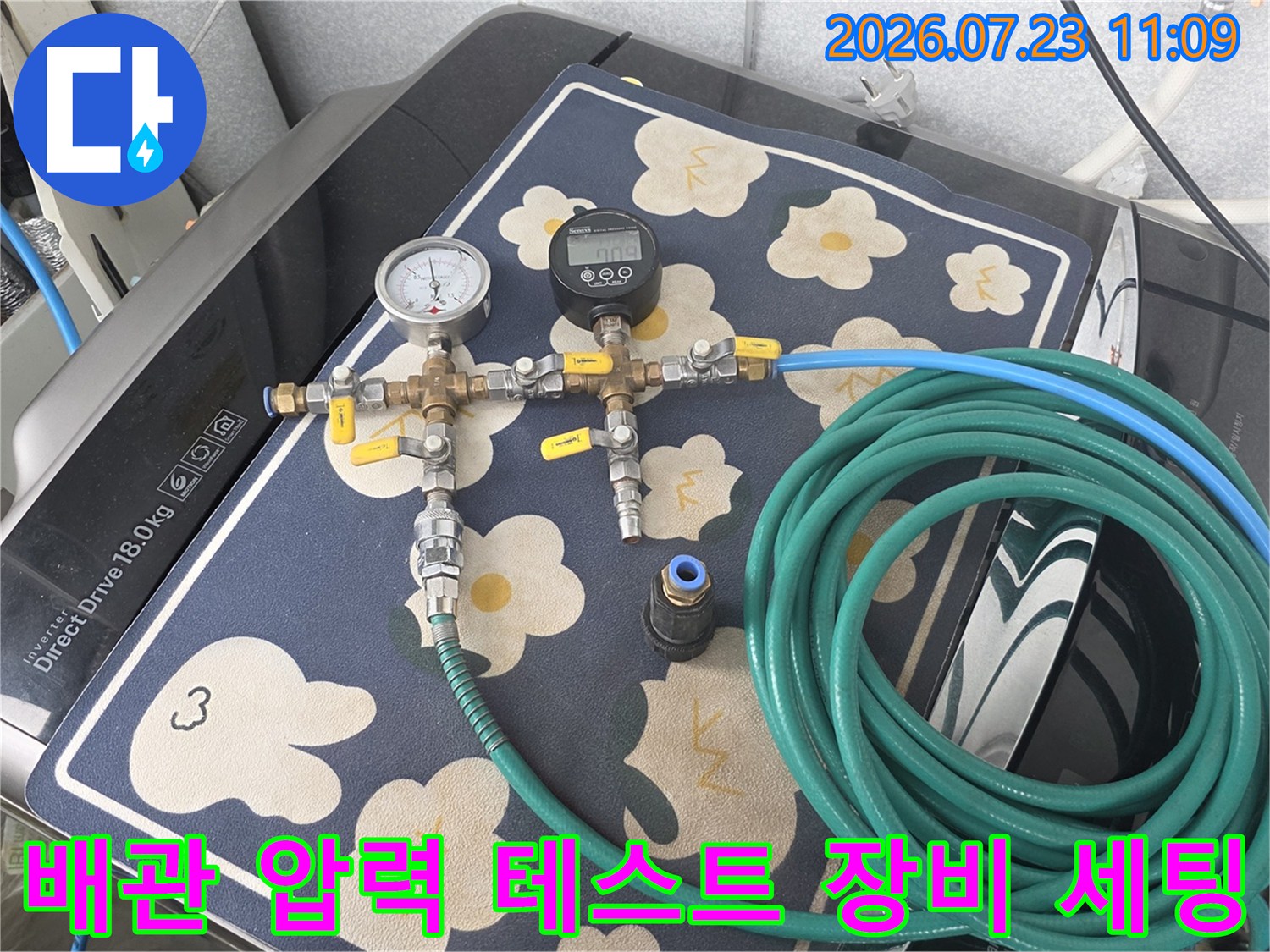 보일러 배관에 연결된 아날로그 압력계와 디지털 측정기가 포함된 누수 탐지 장비-초록색 호스가 연결되어 있음