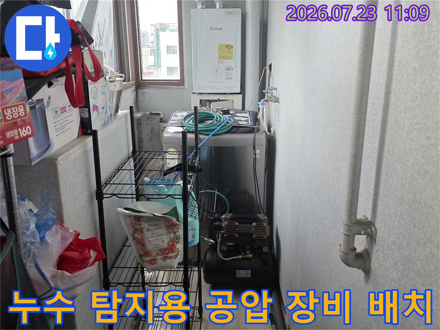 흰색 벽면의 보일러 아래쪽에 배치된 검은색 누수 탐지기-공압 테스트 준비 상태