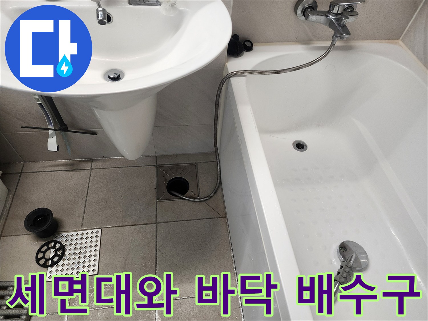 세면대 아래 공간과 화장실 바닥 배수구가 촬영된 사진입니다.