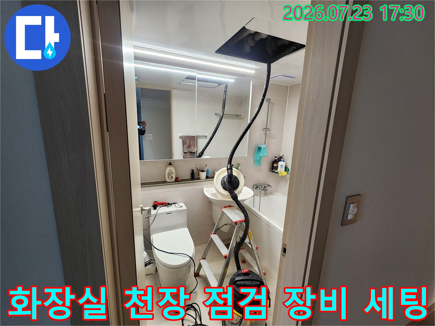 욕실 천장의 점검구를 통해 내부를 확인하기 위해 설치된 검은색 가림막과 집진기-사다리 모습