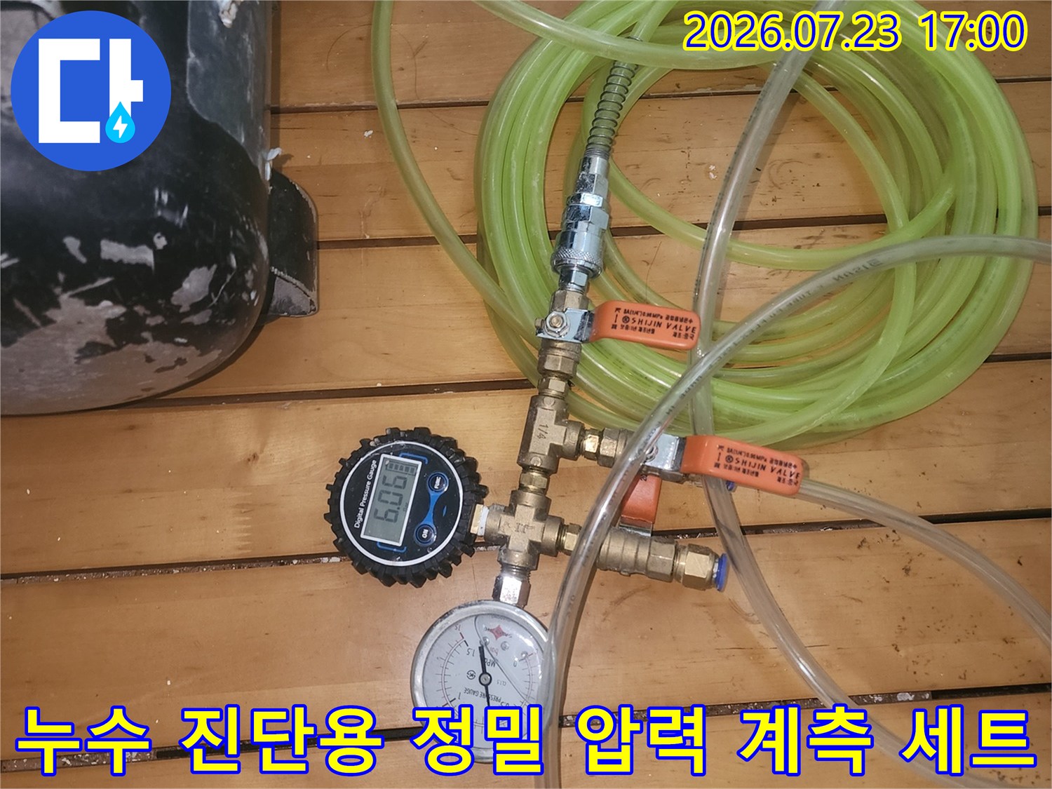 금속제 밸브와 노란색 호스 그리고 디지털-아날로그 게이지가 연결된 모습-사진