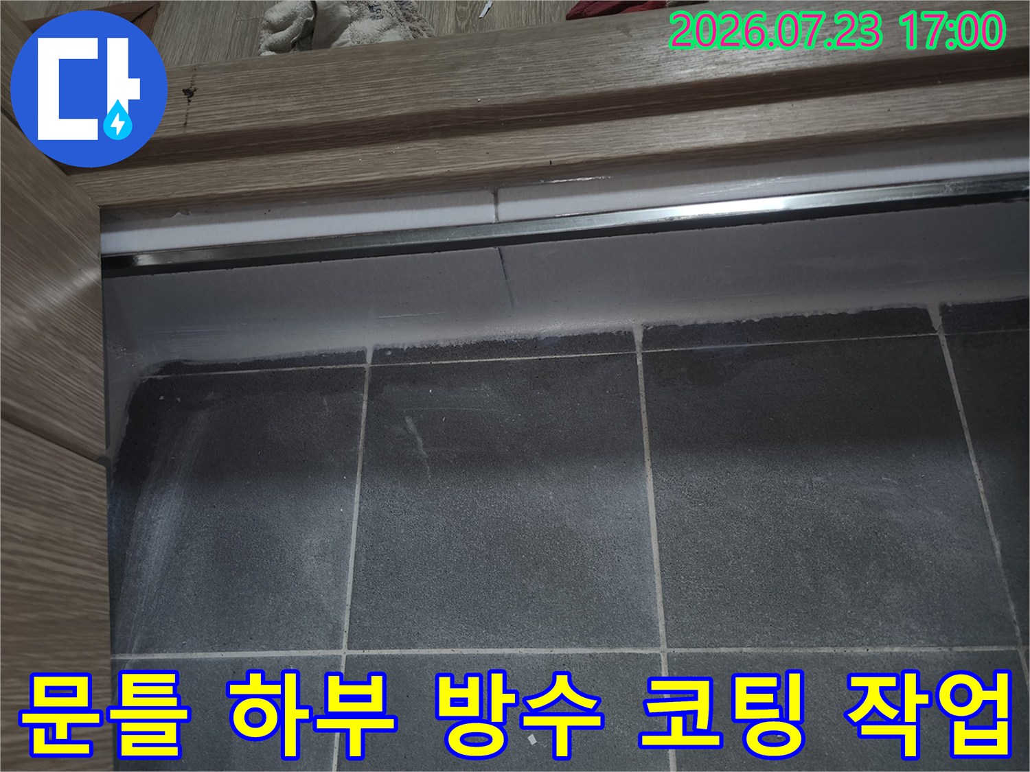나무-프레임과-회색-타일-경계면에-시공된-백색-실리콘-마감재