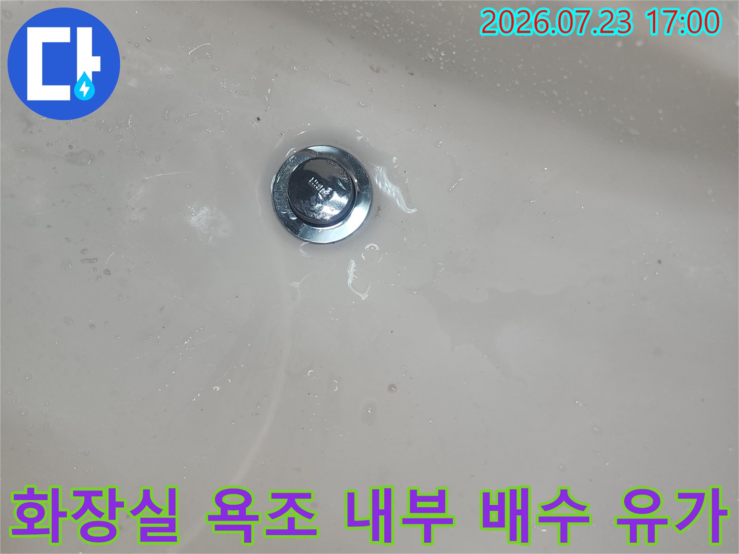매끄러운 흰색 욕조 표면과 중앙의 금속제 배수구-배관 연결 지점