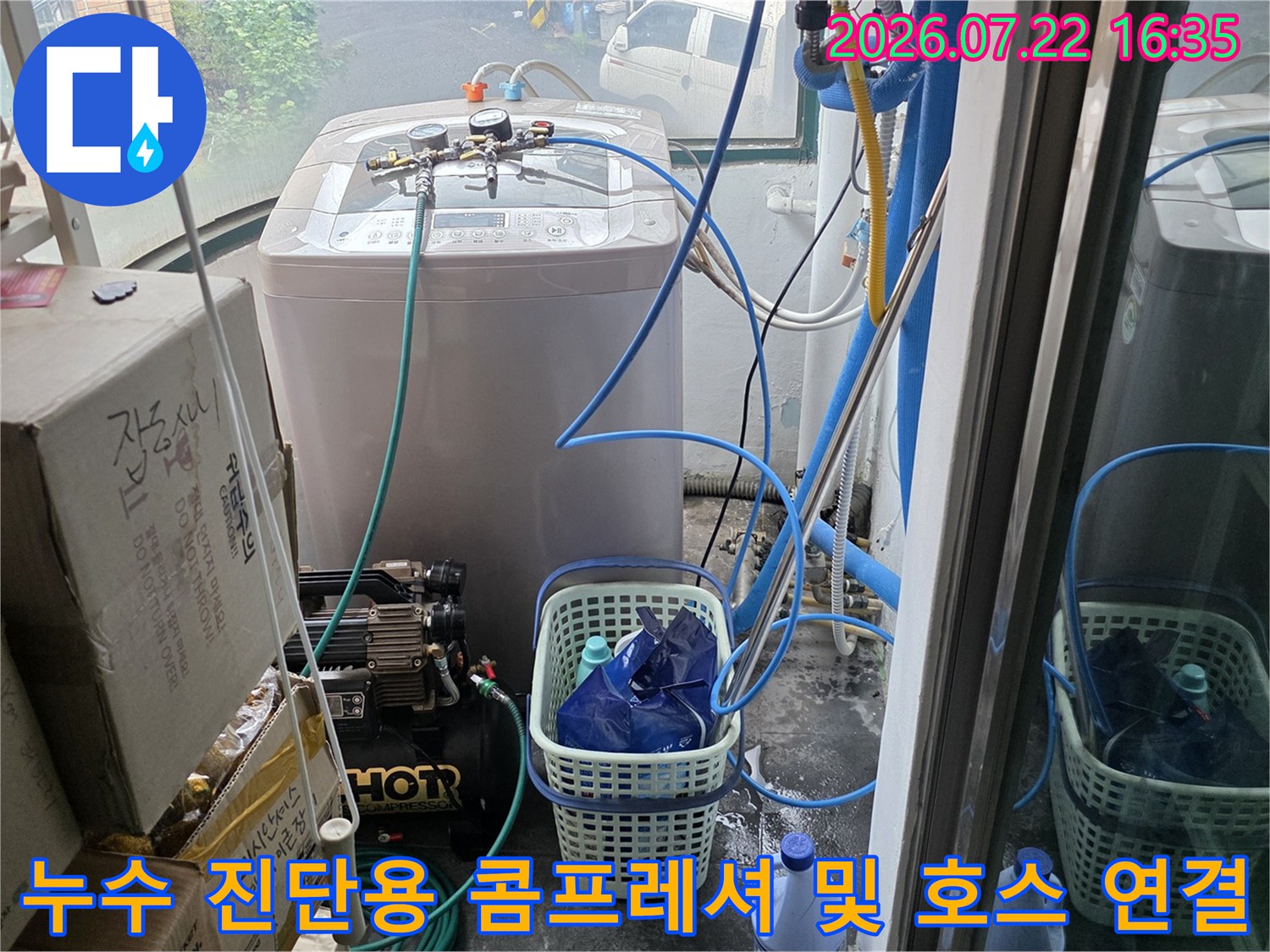 다용도실 바닥에 놓인-누수 탐지 장비와 파란색 배관 연결선들