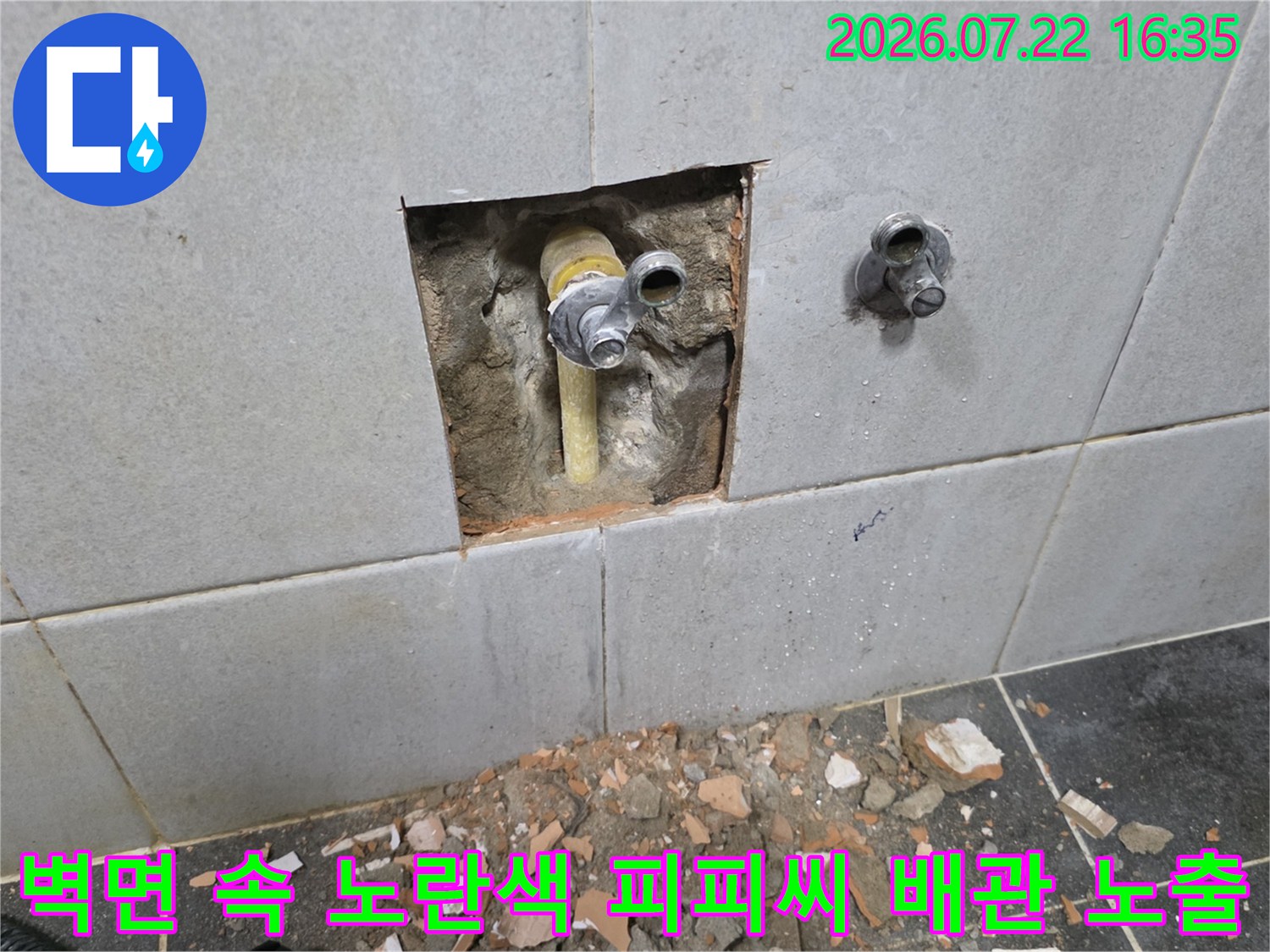벽타일을 걷어내고 나타난 노후된 노란색 수도 배관과 연결 부속의 모습