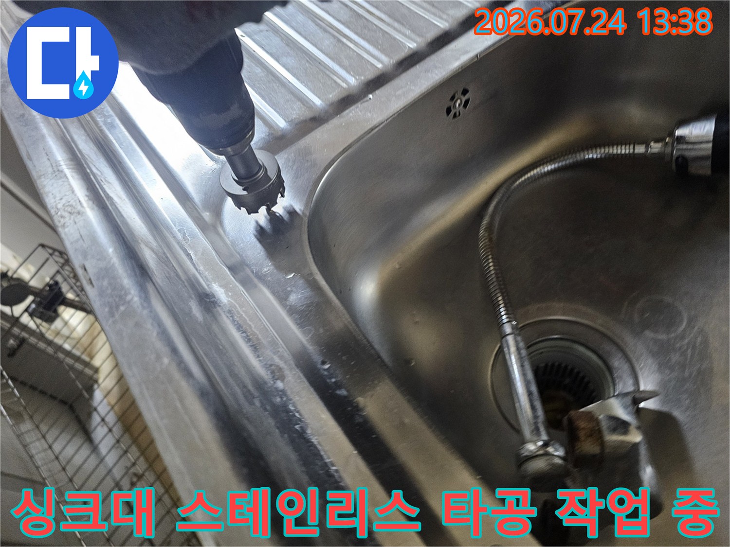 금속제 싱크대 볼 가장자리에 전동 공구로 구멍을 내는 작업 사진