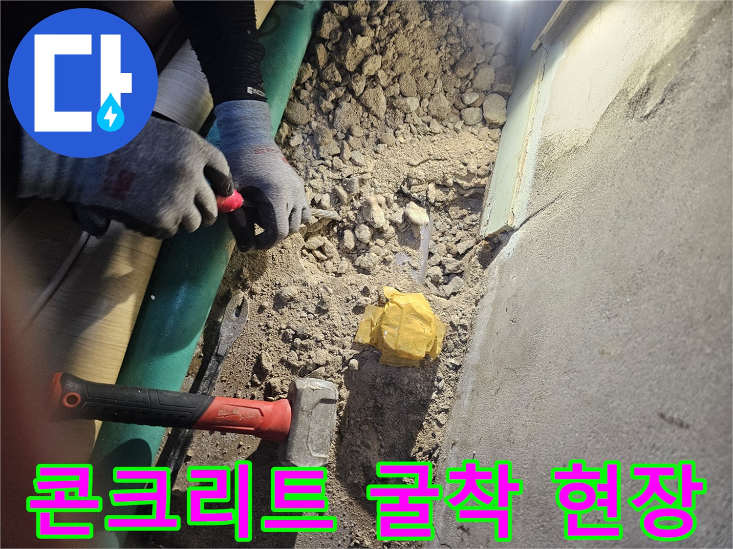 바닥의 파손된 시멘트와 작업용 망치가 놓여있는 사진입니다.