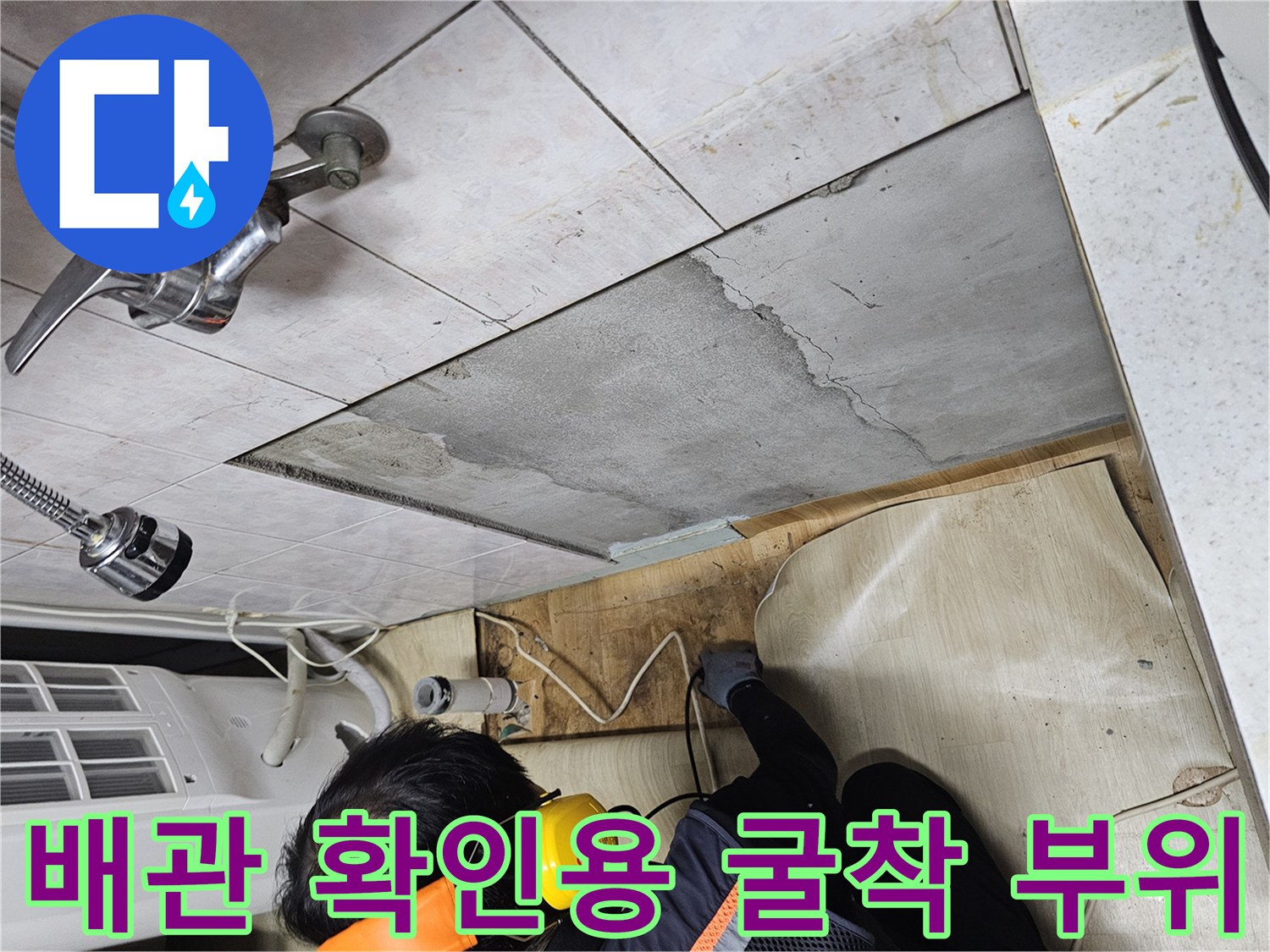 싱크대 주변 타일을 걷어내고 콘크리트 층을 파낸 배관 점검 현장입니다.