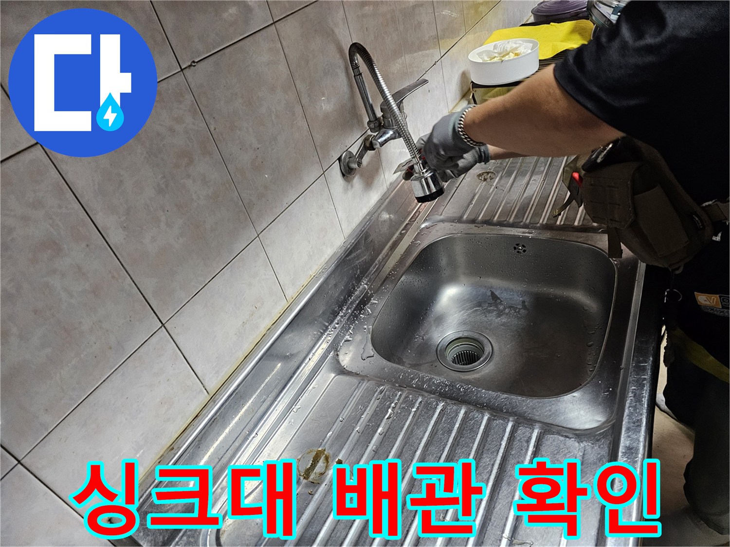싱크대 하단 수전 부위의 누수 상태를 직접 점검하는 모습