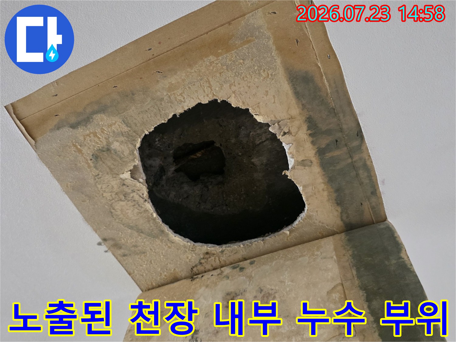 거실 천장의 마감재를 제거하고 콘크리트 내부의 배관 연결부가 드러난 장면