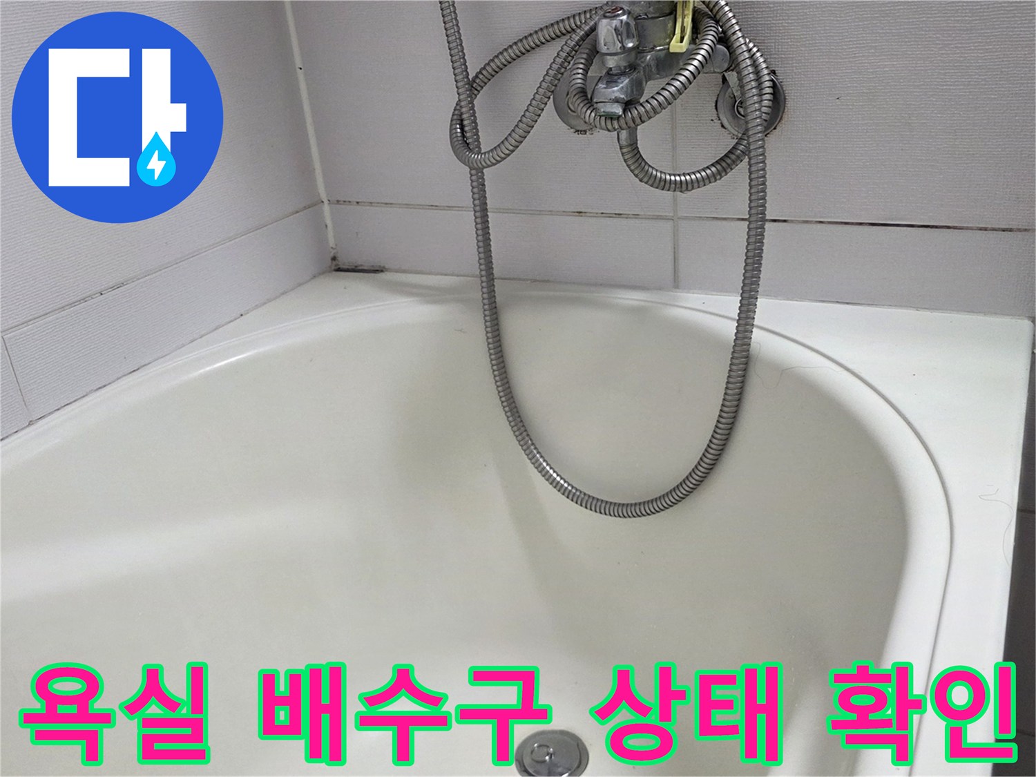 깨끗한 화이트 톤 욕실의 배수구와 샤워기 호스 모습