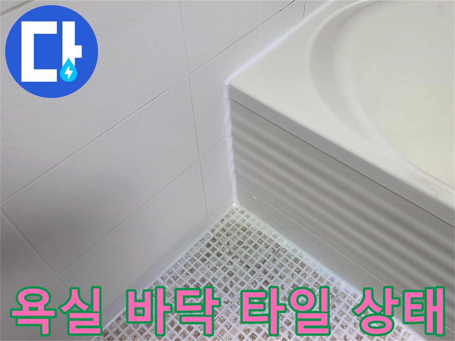 하얀색 욕실 타일과 배수구 주변의 모습입니다.