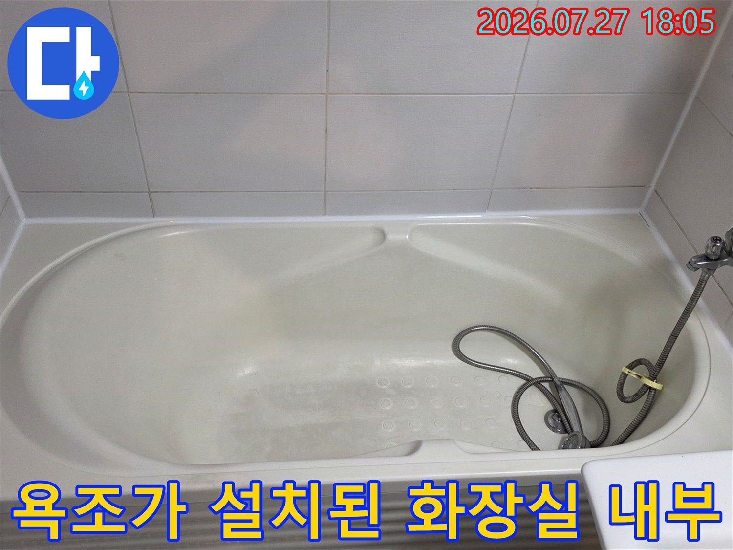 흰색 욕조와 샤워 호스가 놓여 있는-전형적인 아파트 욕실의 모습