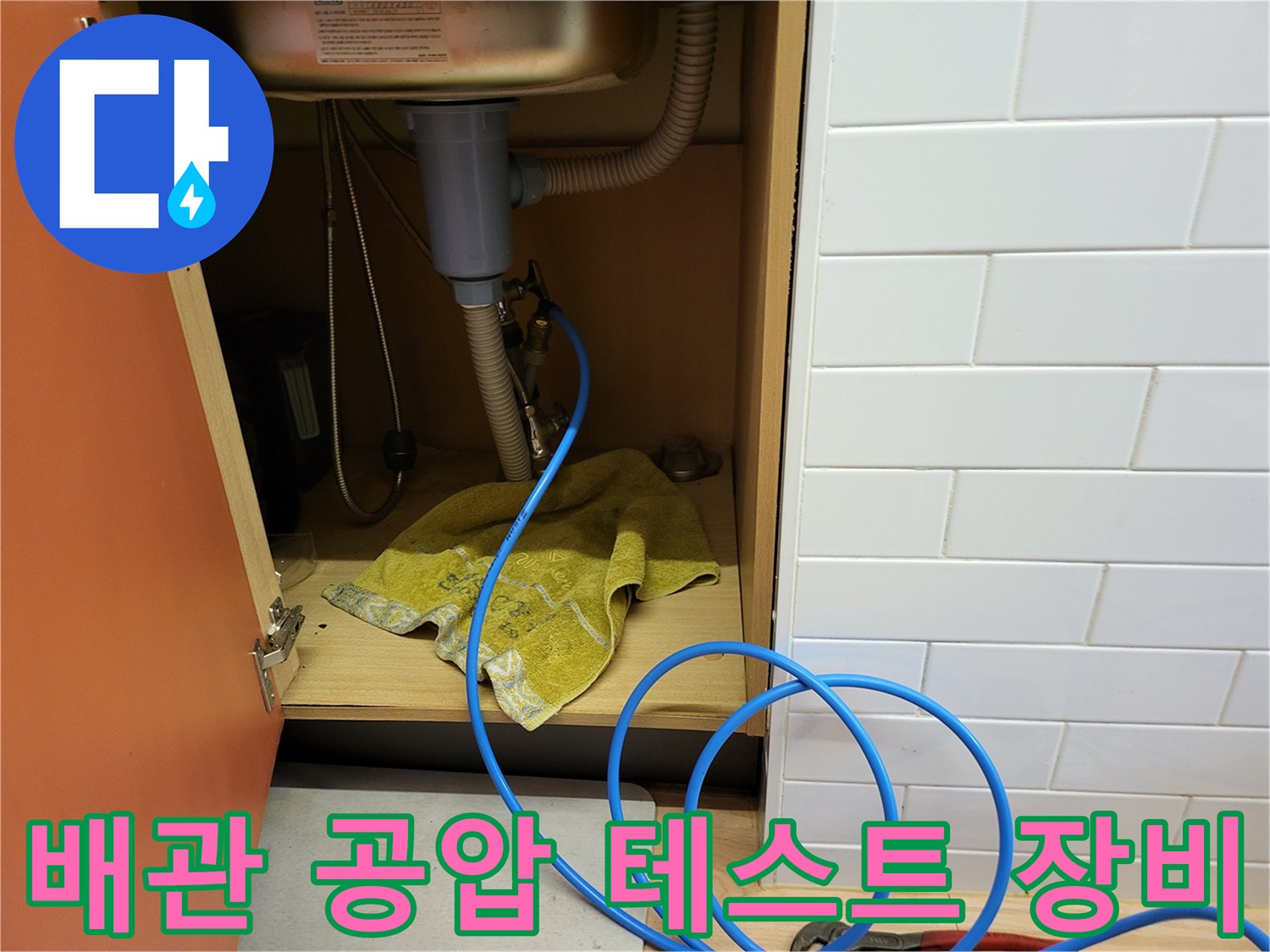 싱크대 하부 배관에 연결된 파란색 누수 탐지 호스